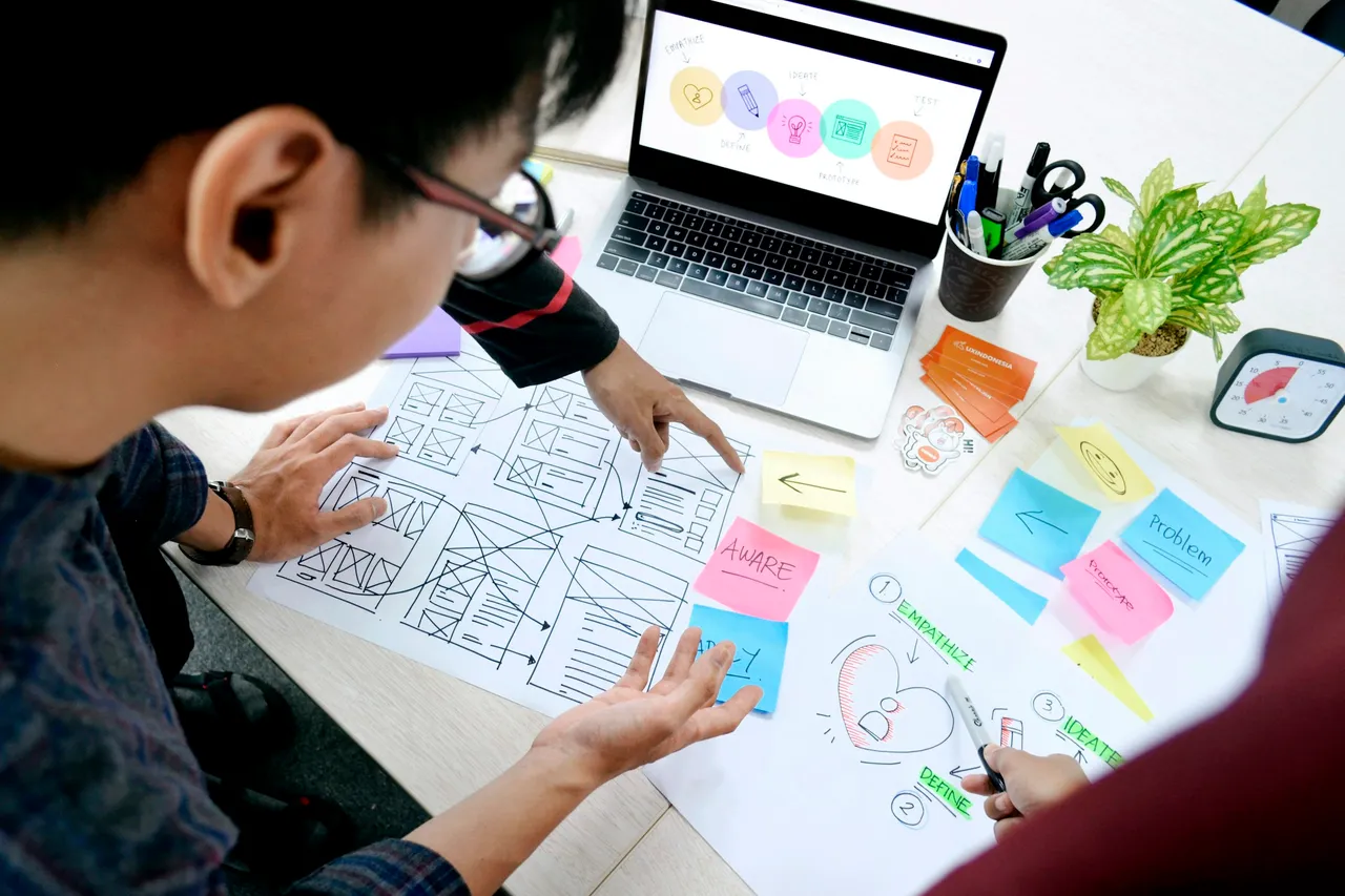 Designer arranging website wireframes at a desk