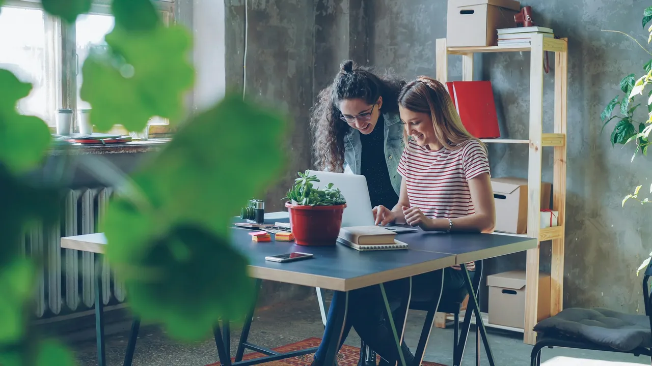 Two colleagues collaborating at a desk in a modern office