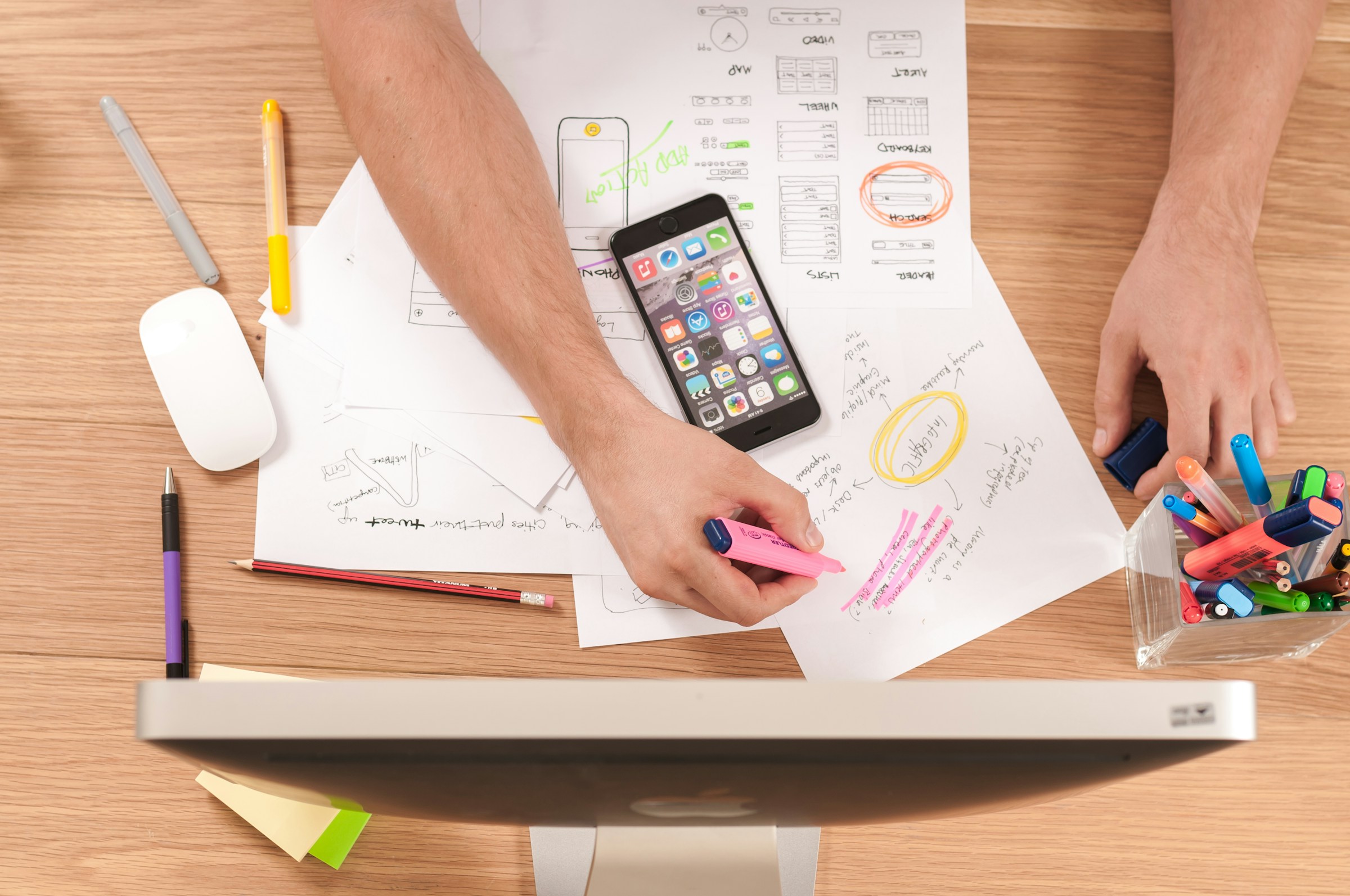 Person planning content with notes and a laptop at a desk