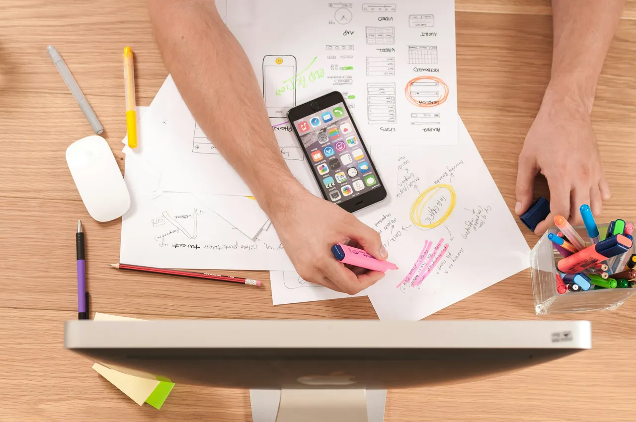 Person planning content with notes and a laptop at a desk